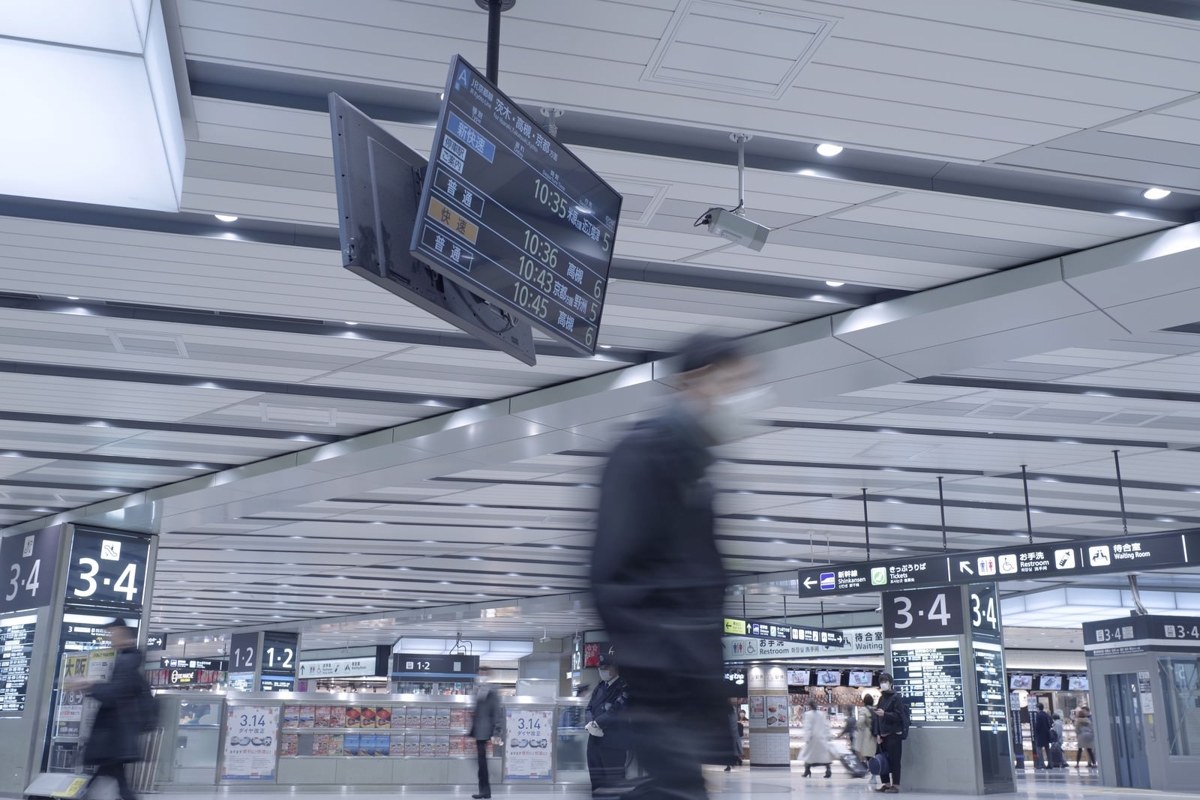 新大阪駅の駅構内を歩く人々と案内表示板